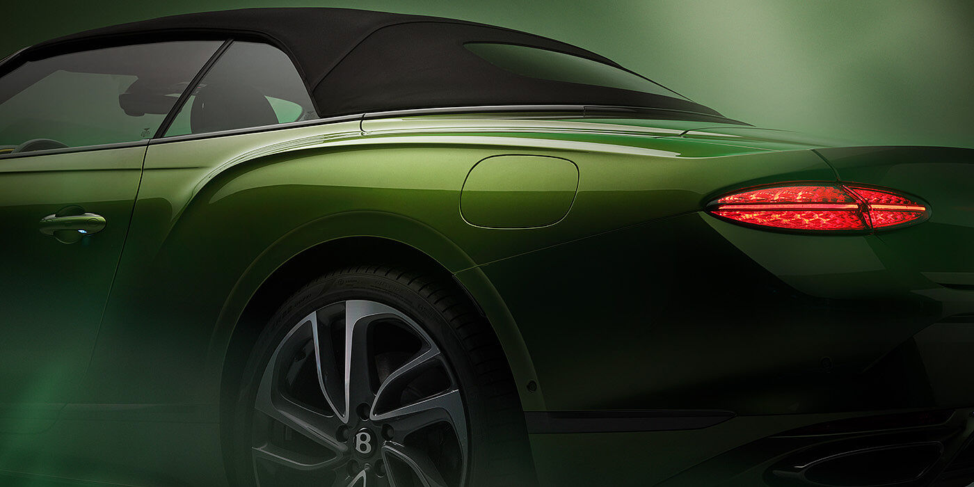 Bentley Melbourne Bentley New Continental GTC Speed rear haunch and tail lamp in Tourmaline Green paint and dark tint brightware with black hood up and illuminated head lamps