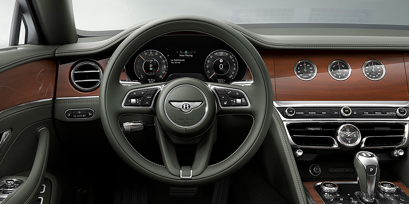 Bentley Melbourne New Bentley Flying Spur sedan front cabin in Cumbrian Green hide and Crown Cut walnut veneer showing steering wheel and Rotating Display with three clocks on face