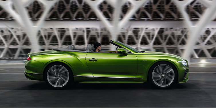 Bentley Melbourne Bentley Continental GTC Speed convertible side profile in Tourmaline Green paint driving dynamically on a bridge at night