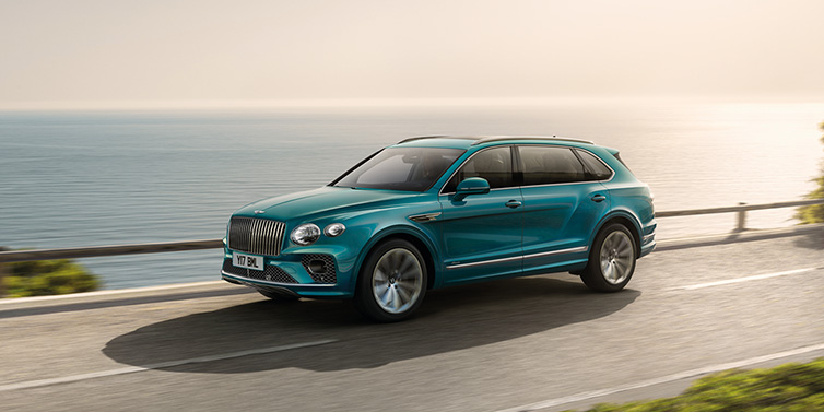 Bentley Melbourne Bentley Bentayga Extended Wheelbase Azure SUV in Topaz blue paint driving dynamically by the ocean