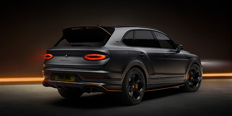 Bentley Melbourne Bentley Bentayga S Black Edition SUV rear three quarter in Anthracite Satin paint against a dark red and yellow background