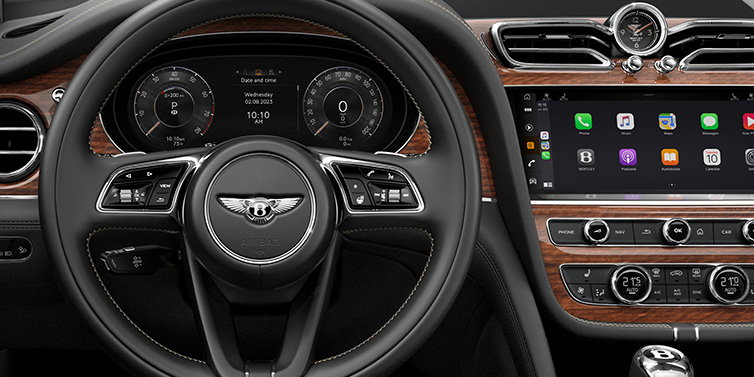 Bentley Melbourne Bentley Bentayga SUV front interior detail of steering wheel and driver screens surrounded by Beluga black hide and Crown Cut Walnut veneer