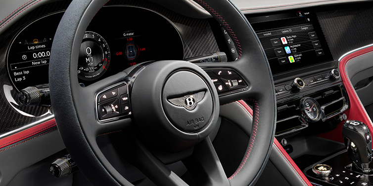 Bentley Melbourne Bentley Flying Spur Speed sedan front interior detail showing steering wheel and driver screens surrounded with Hotspur red and Gravity Grey hides